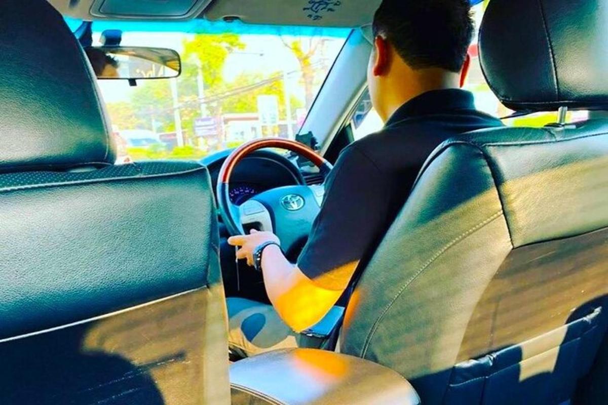 muž řídící auto se surfovacím prknem na palubní desce