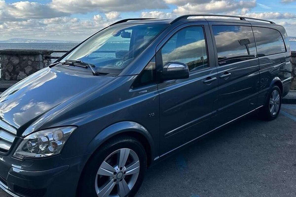 Modrá dodávka zaparkovaná na parkovišti poblíž oceánu