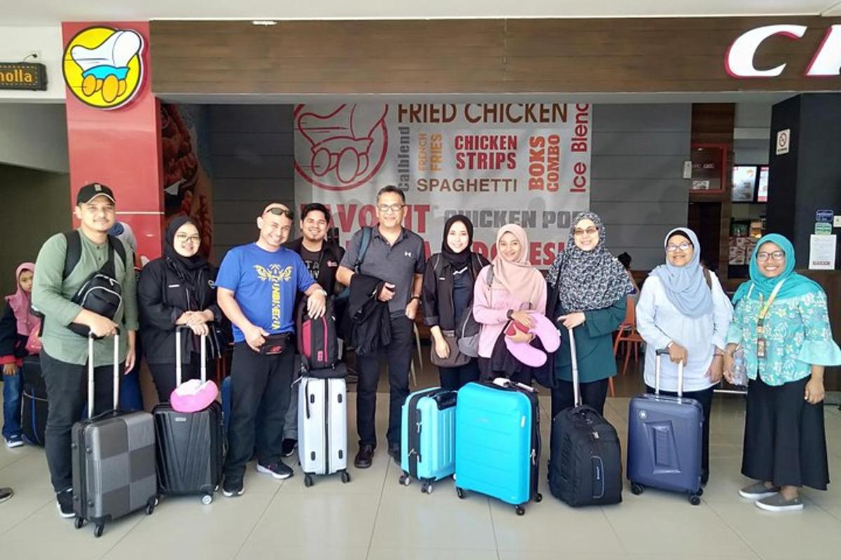 a group of people posing for a picture with their luggage