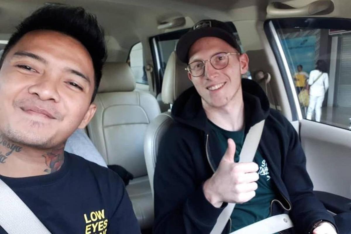 two men sitting in a car giving a thumbs up