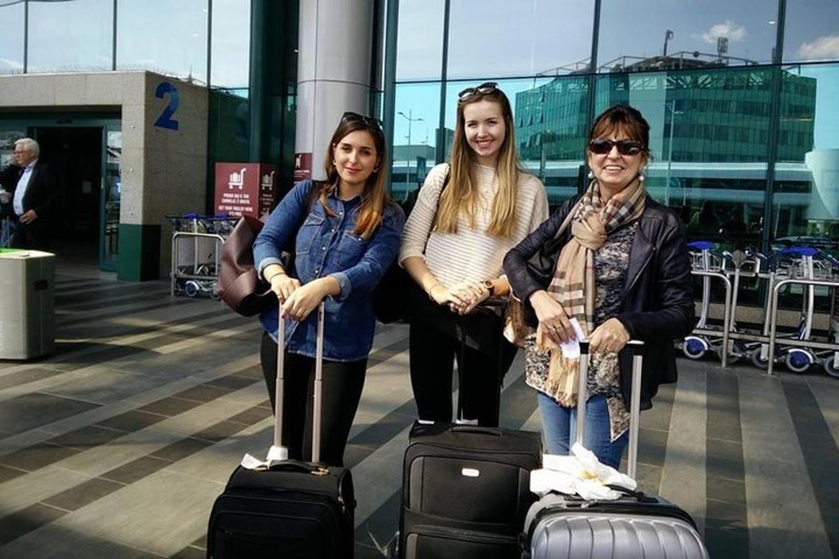 tři ženy pózující se svými zavazadly na letišti
