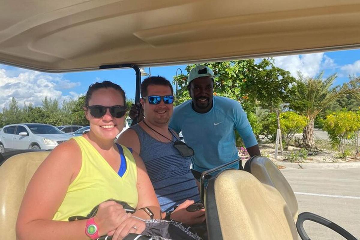 two men and a woman riding in a golf cart