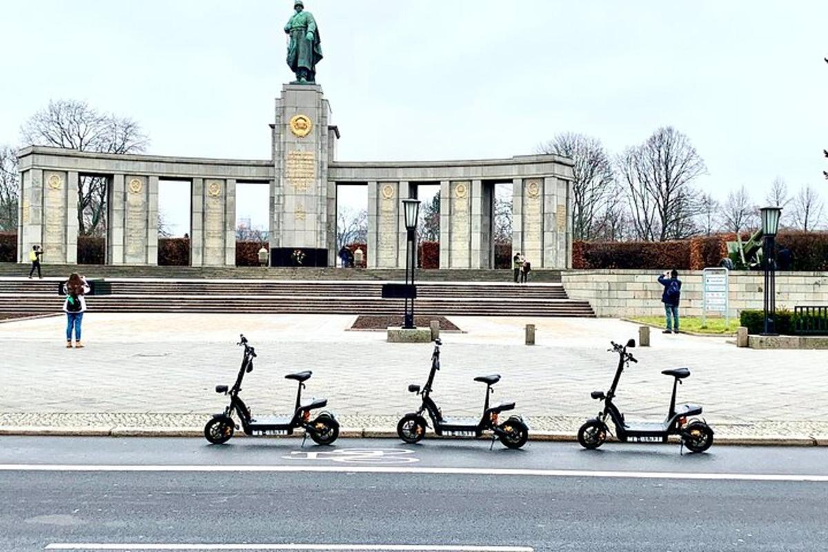 egy csoport robogó parkolt egy emlékmű előtt