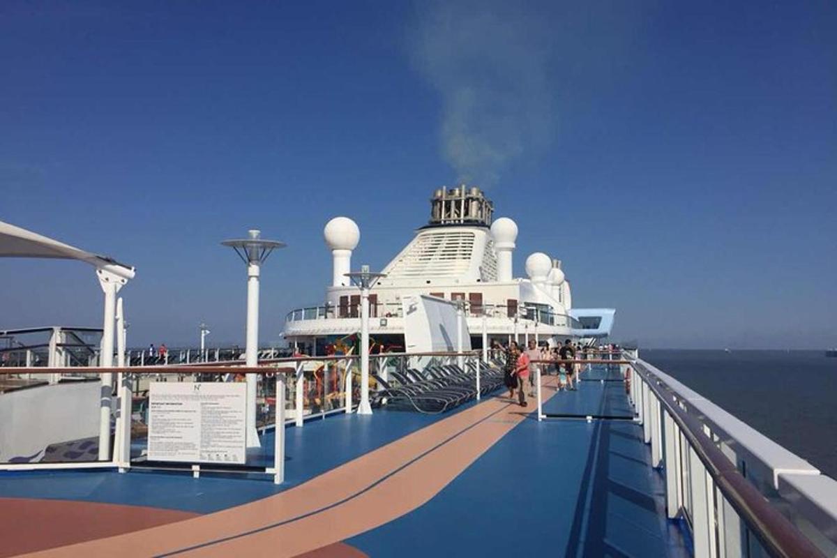 a cruise ship on the ocean with people on the deck