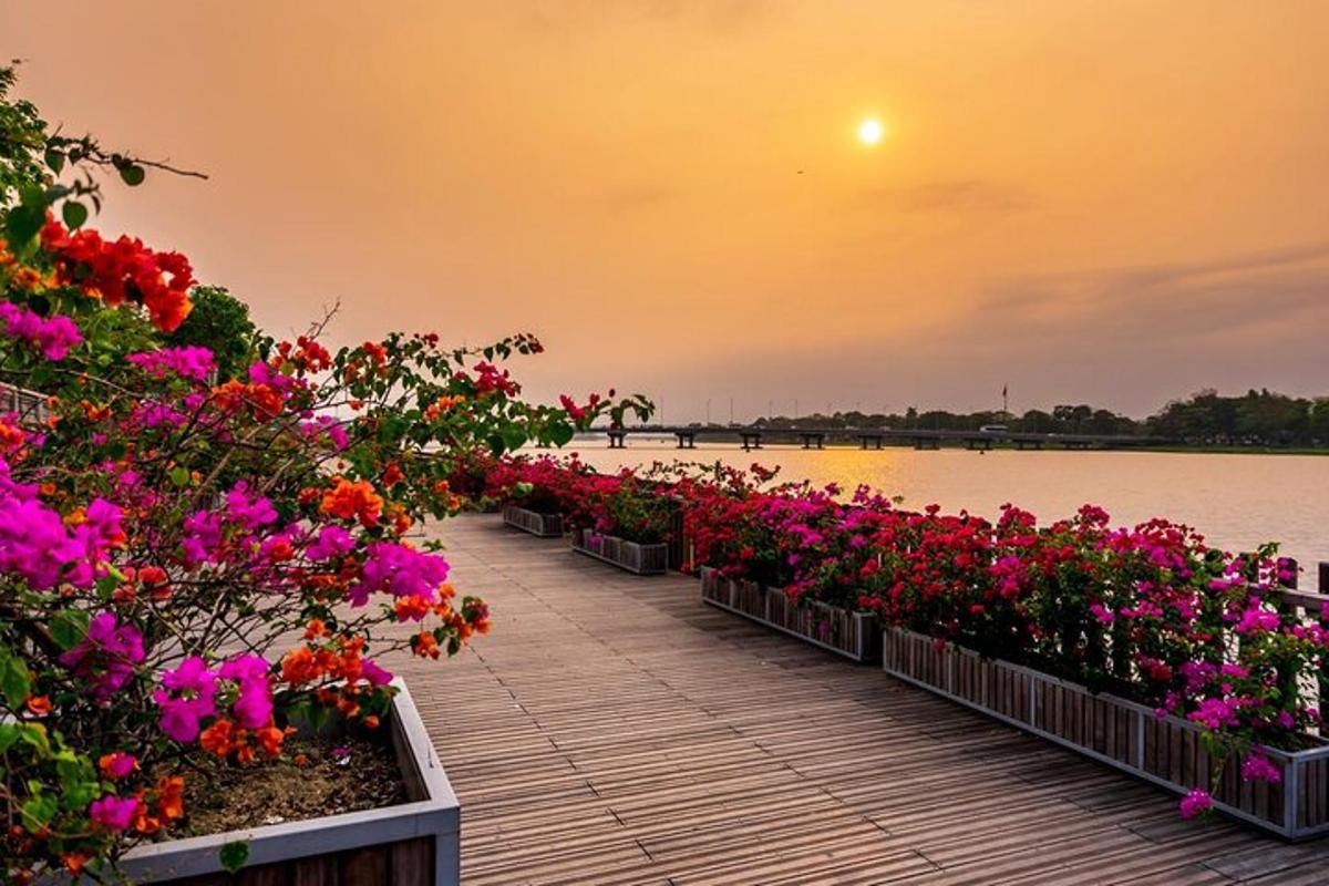 một hàng hoa trên lối đi lát ván gần bờ nước
