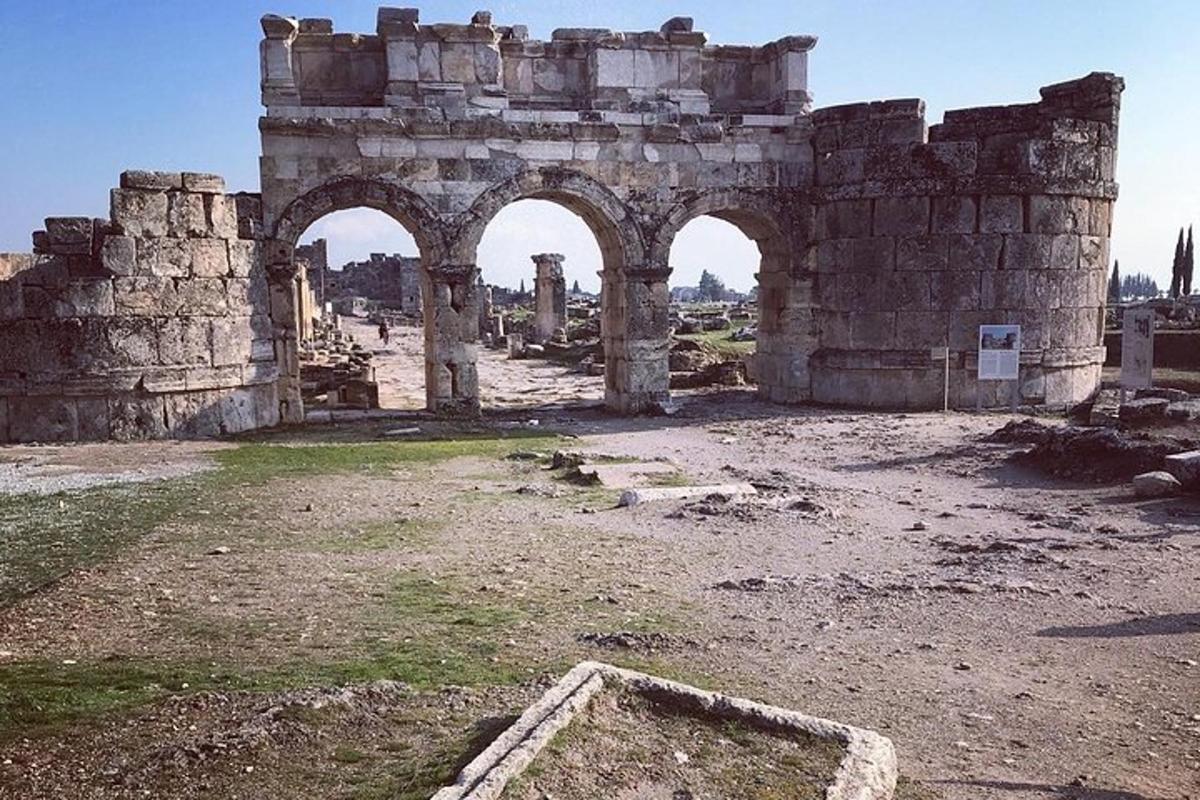 un vecchio edificio con tre archi in un campo