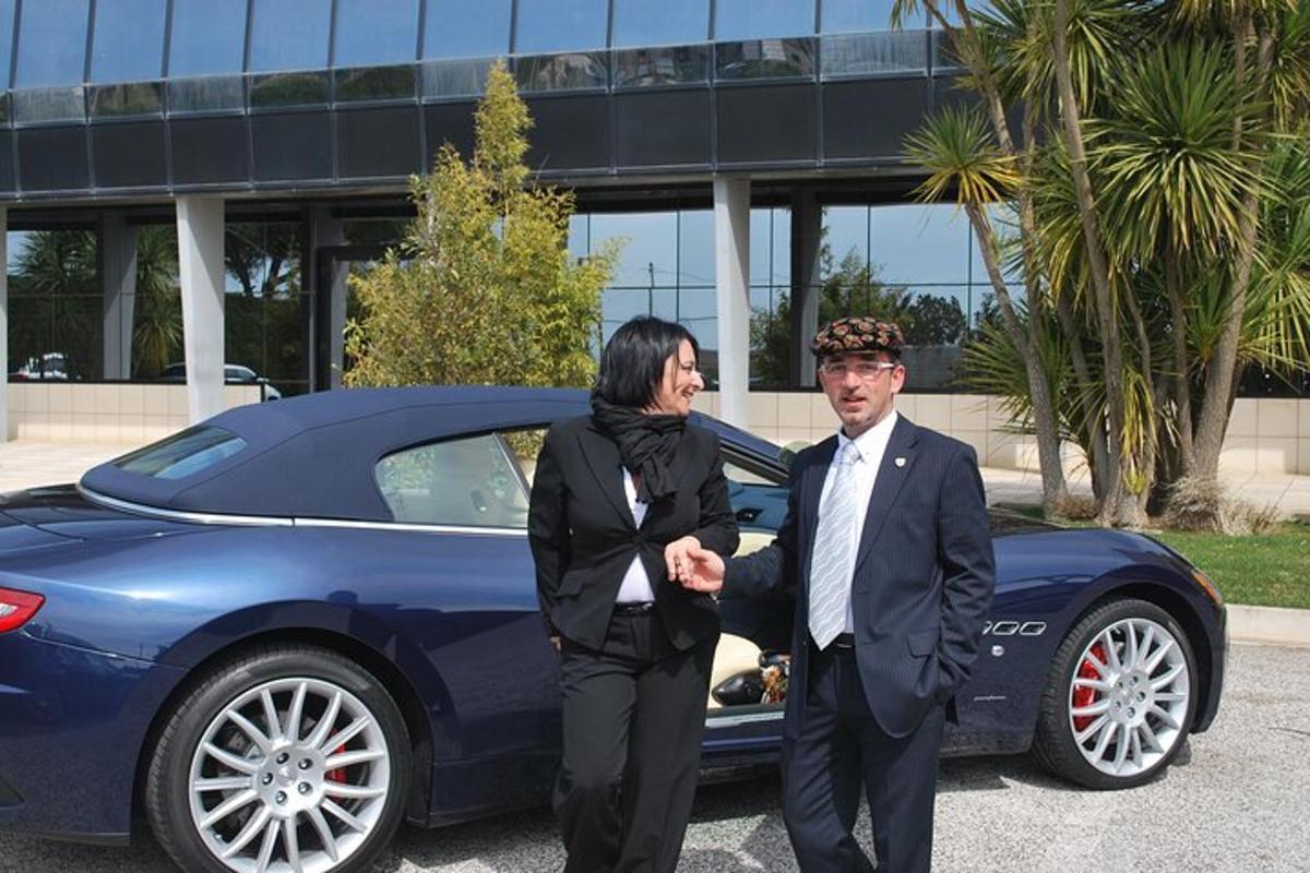 um homem e uma mulher parados ao lado de um carro azul