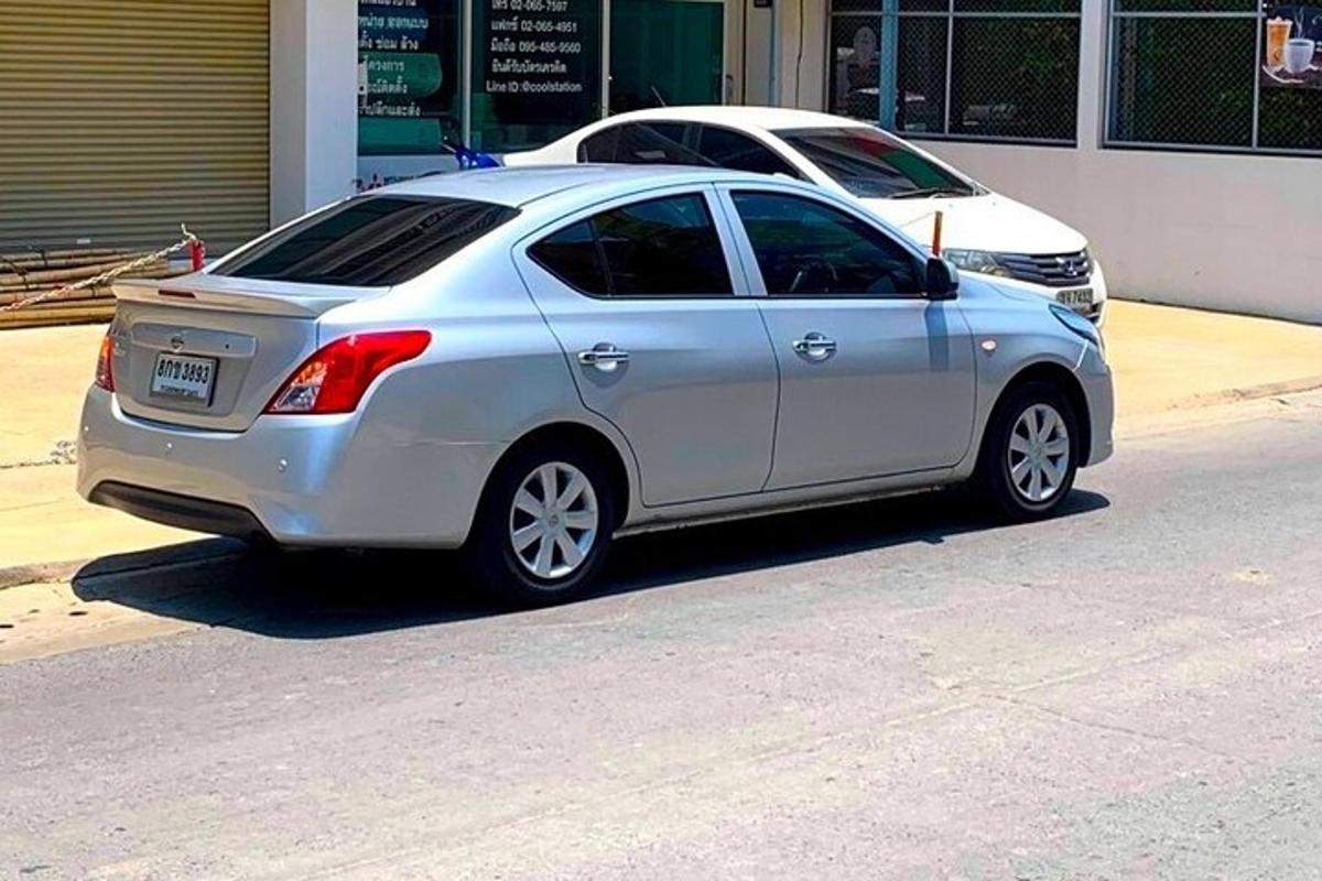 Un coche plateado aparcado al costado de una calle