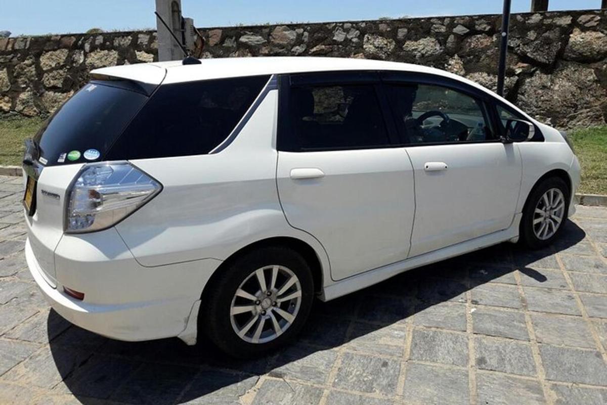 a white small car parked on a brick street