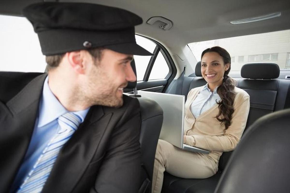 a man and a woman sitting in a car with a laptop