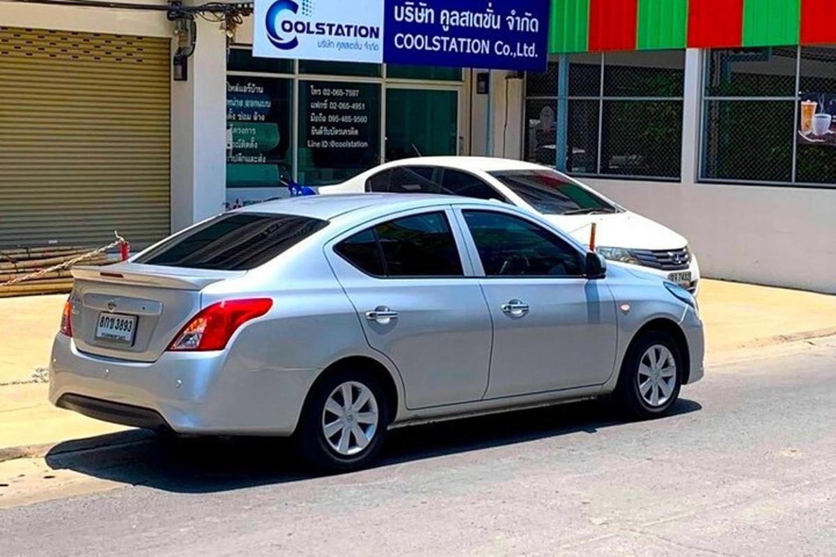 stříbrné auto zaparkované před obchodem