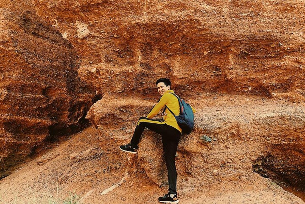 um homem com uma mochila sentado em uma pedra