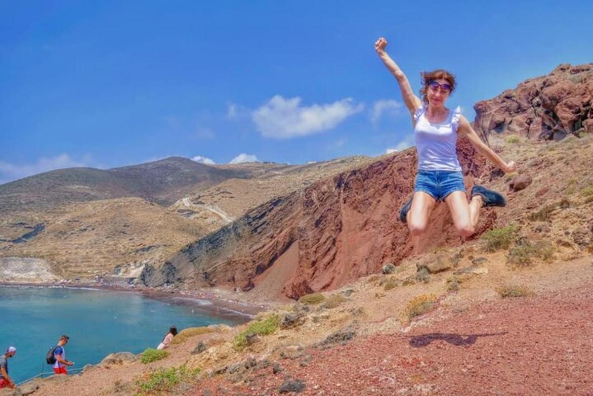 seorang wanita duduk di atas bukit di sebelah badan air