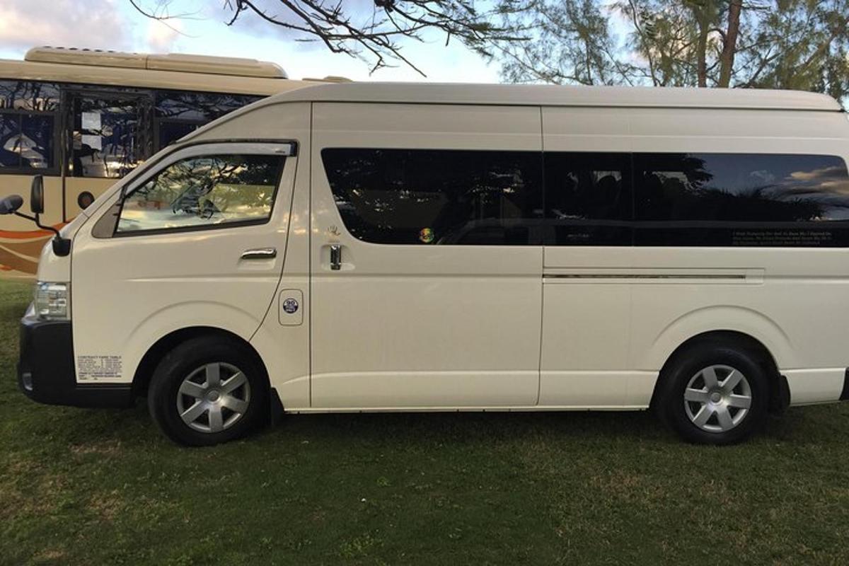 un furgone bianco parcheggiato sull'erba accanto a un autobus