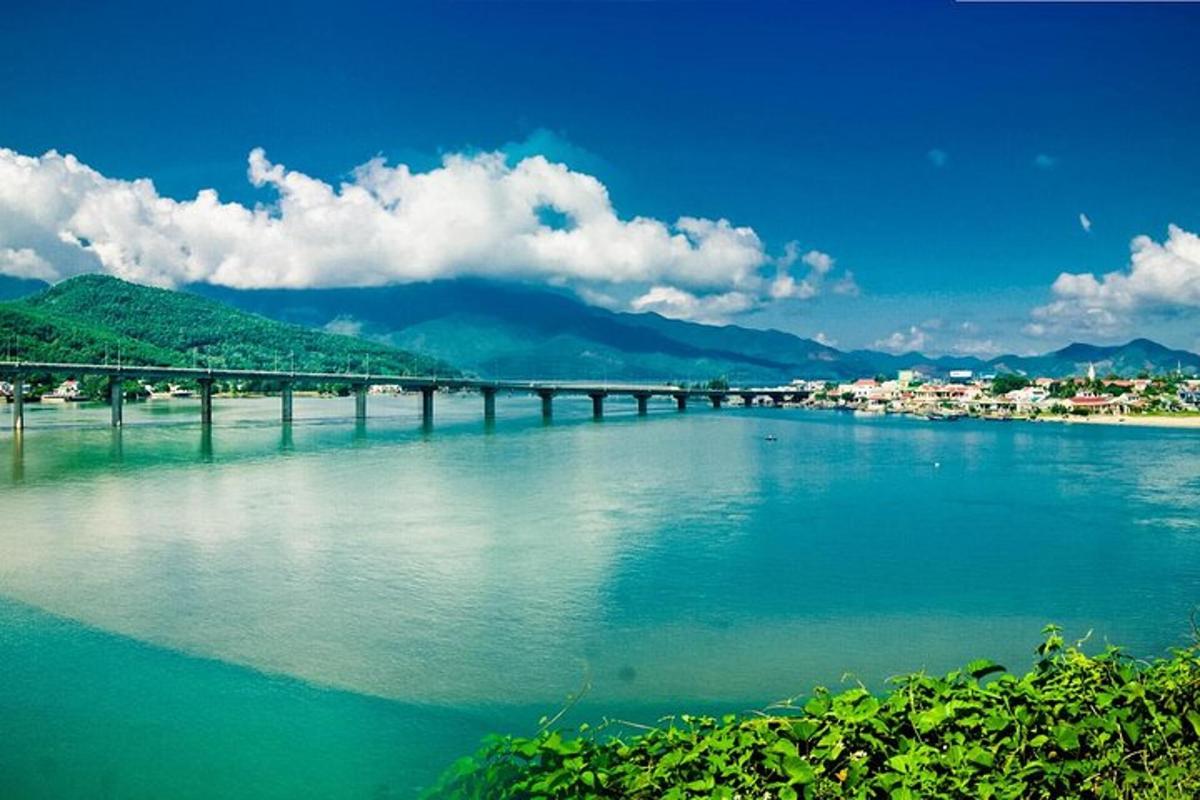 a bridge over a river with a town and mountains