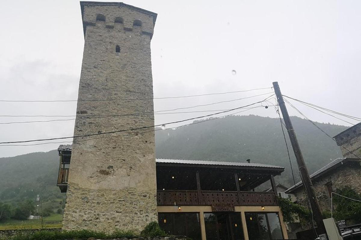 un edificio con un'alta torre accanto a una montagna