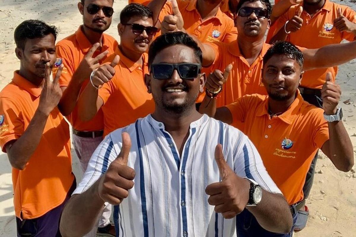 a group of men in orange shirts giving thumbs up