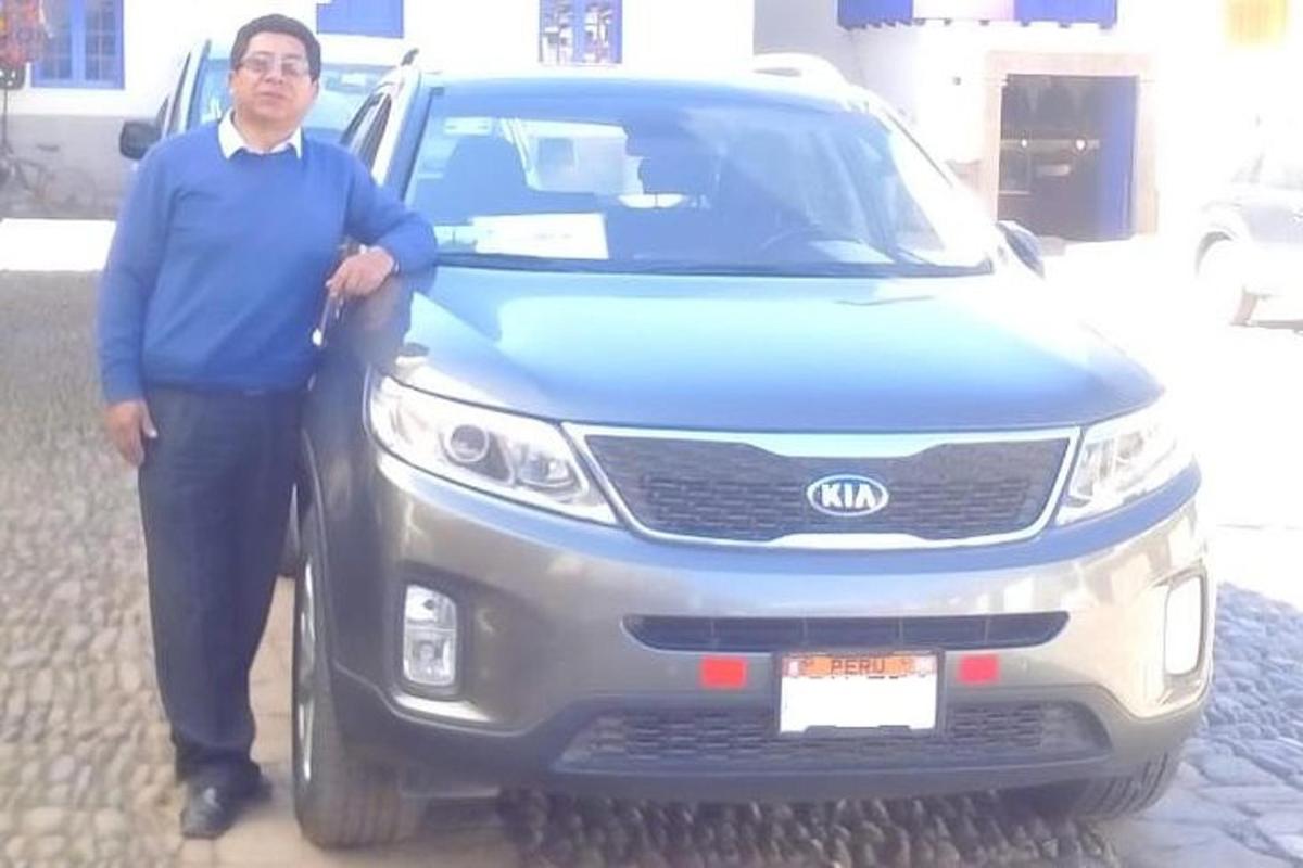un uomo in piedi davanti a un'auto blu