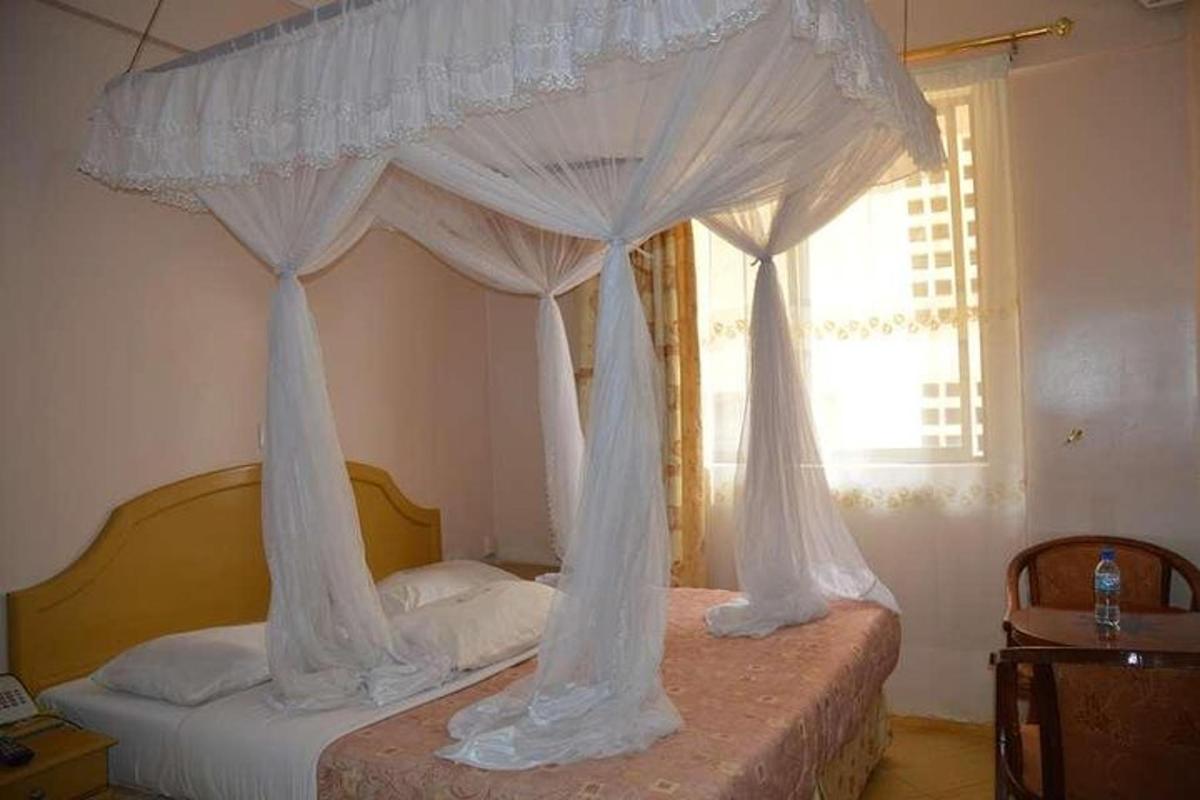 um quarto com uma cama de dossel com cortinas brancas
