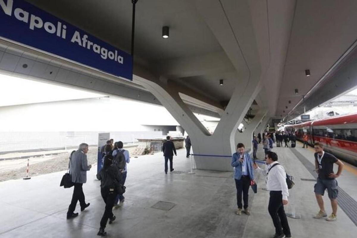 um grupo de pessoas esperando um trem em uma estação de trem