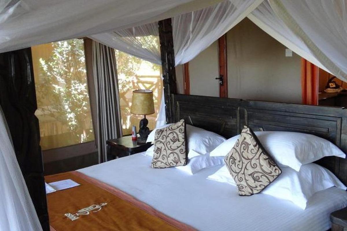 um quarto com uma cama com lençóis e travesseiros brancos
