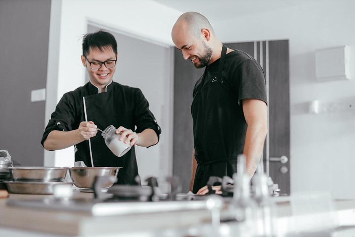 two men standing in a kitchen preparing food