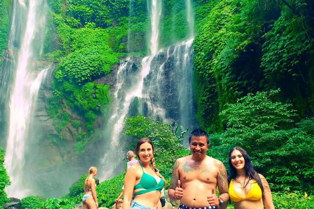 Þrír menn standa fyrir framan foss