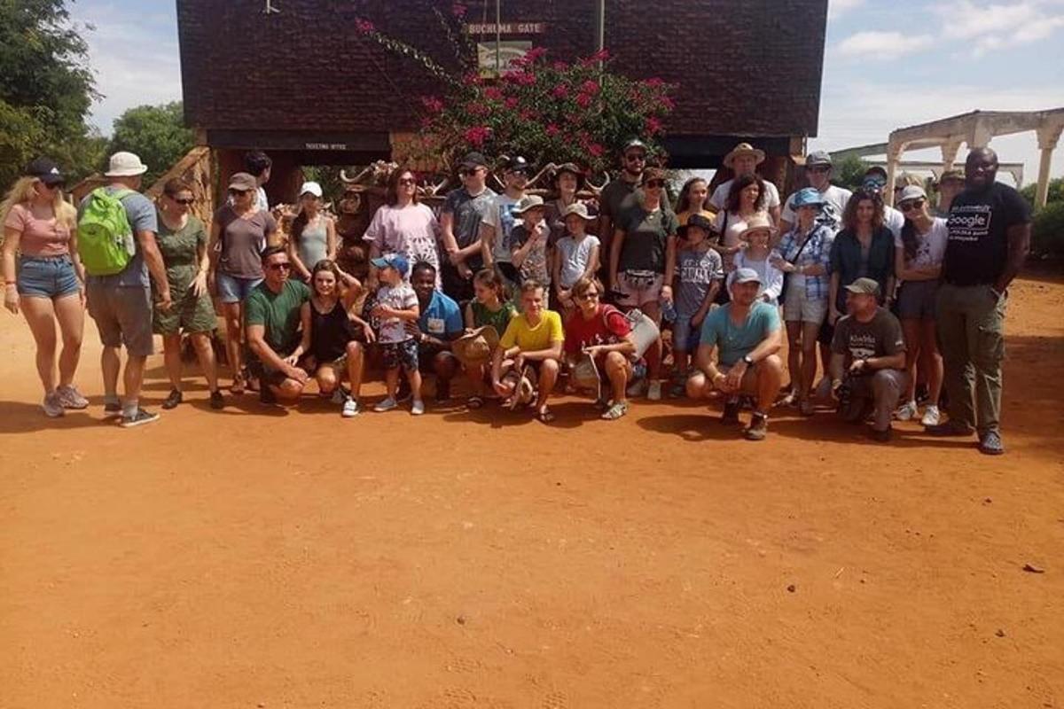 um grupo de pessoas posando para uma foto em um campo de terra