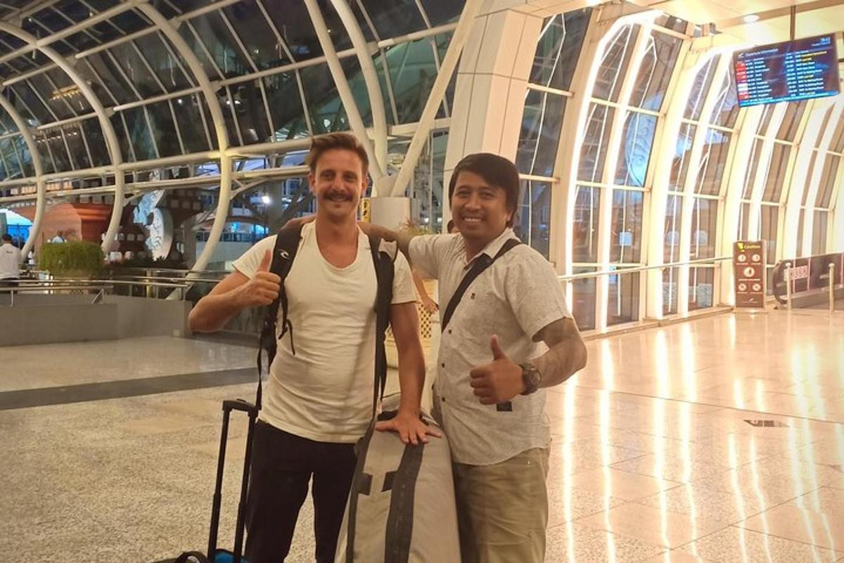 dua lelaki berdiri bersebelahan di lapangan terbang