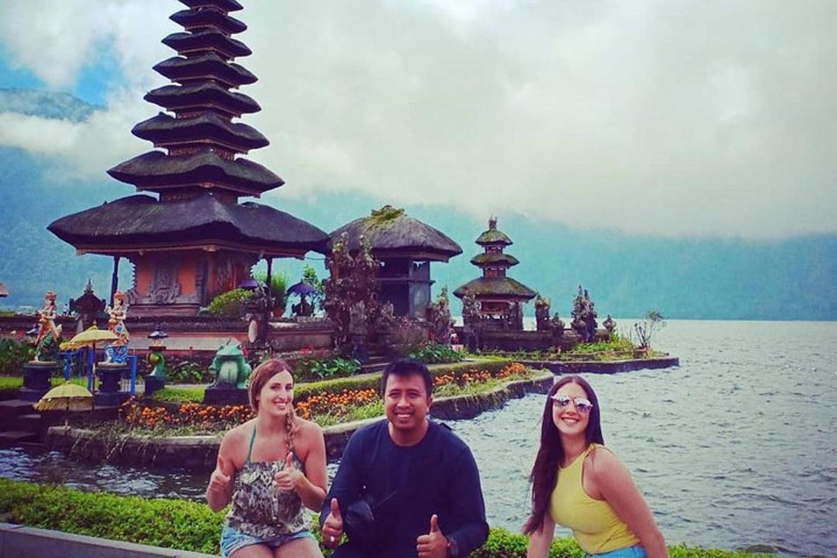 un grup de tres persones dretes davant d'un temple