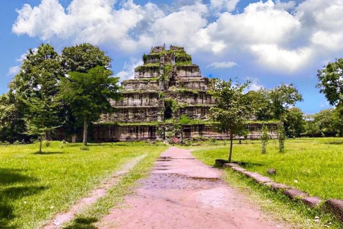 Un gran edificio en un campo con un camino de tierra.