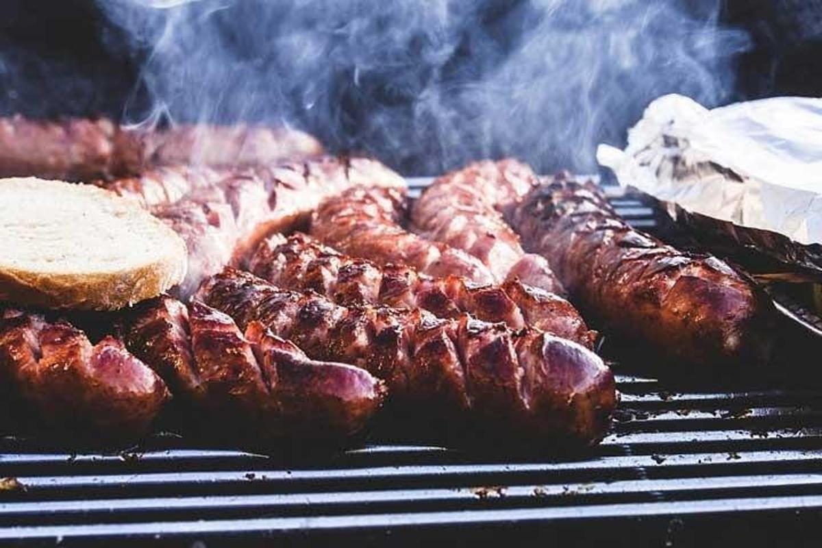 Un montón de carne en una parrilla con humo