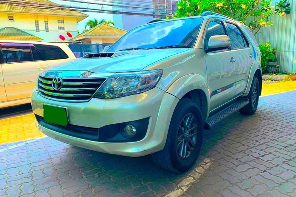 sebuah suv putih diletakkan di jalan batu
