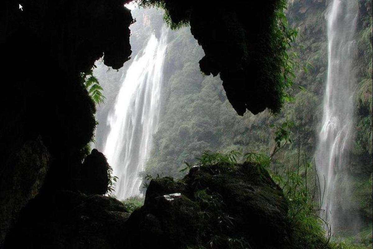 a view of a waterfall from inside a cave