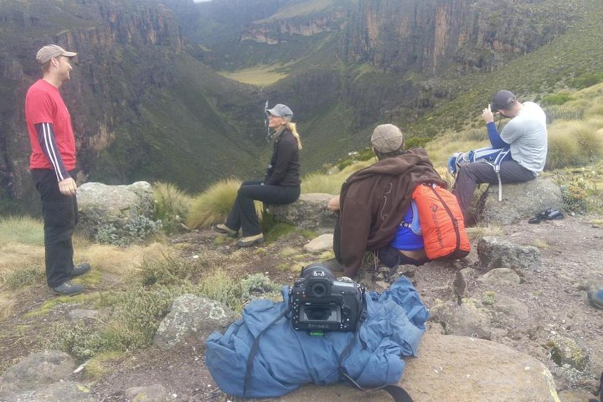 um grupo de pessoas sentadas no topo de uma montanha
