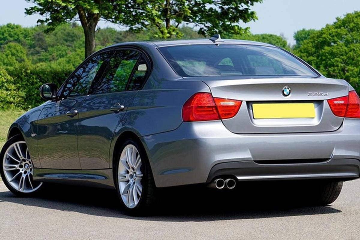 a silver bmw car parked on a road