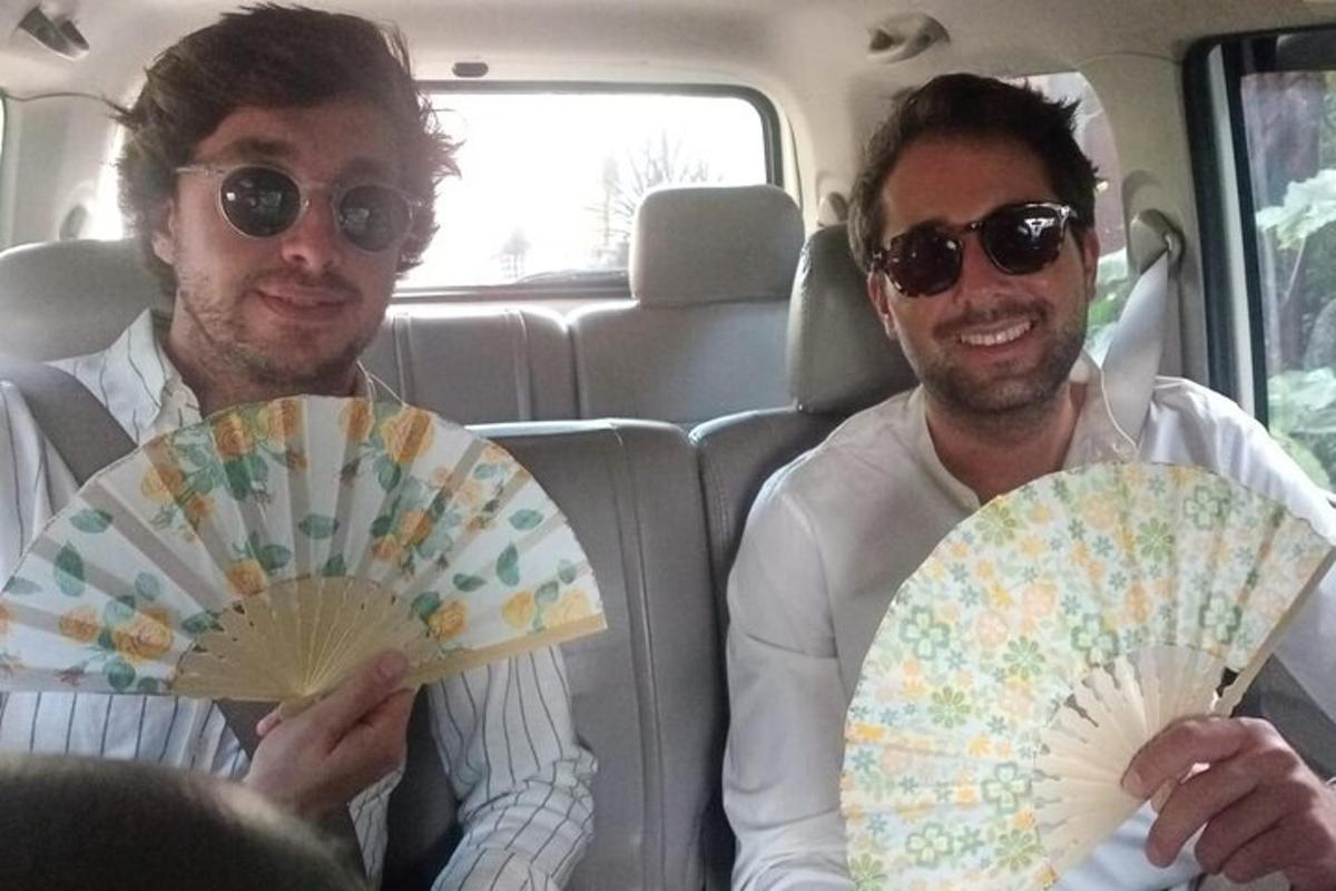 dos homes asseguts en un cotxe amb un ventilador