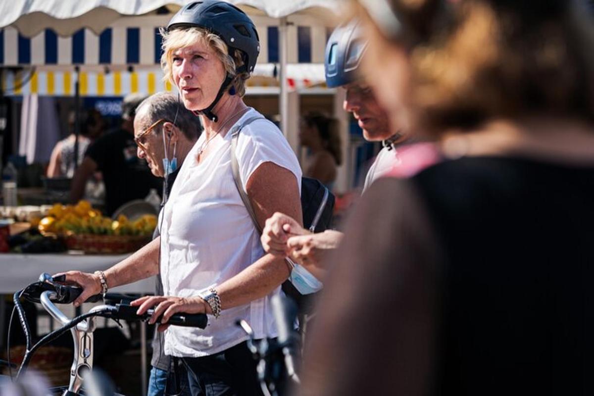 a woman wearing a helmet standing with a bike