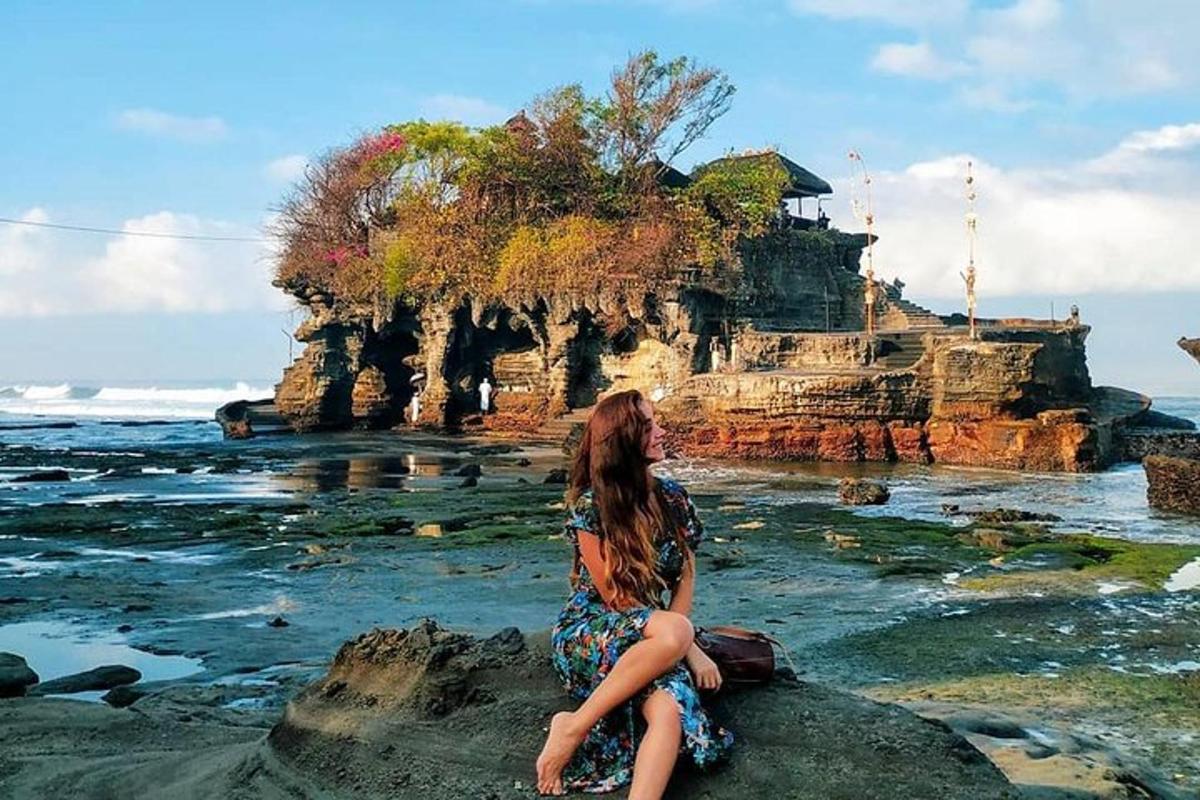žena sedící na skále poblíž oceánu