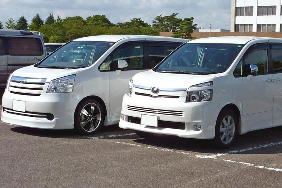two white vans parked in a parking lot