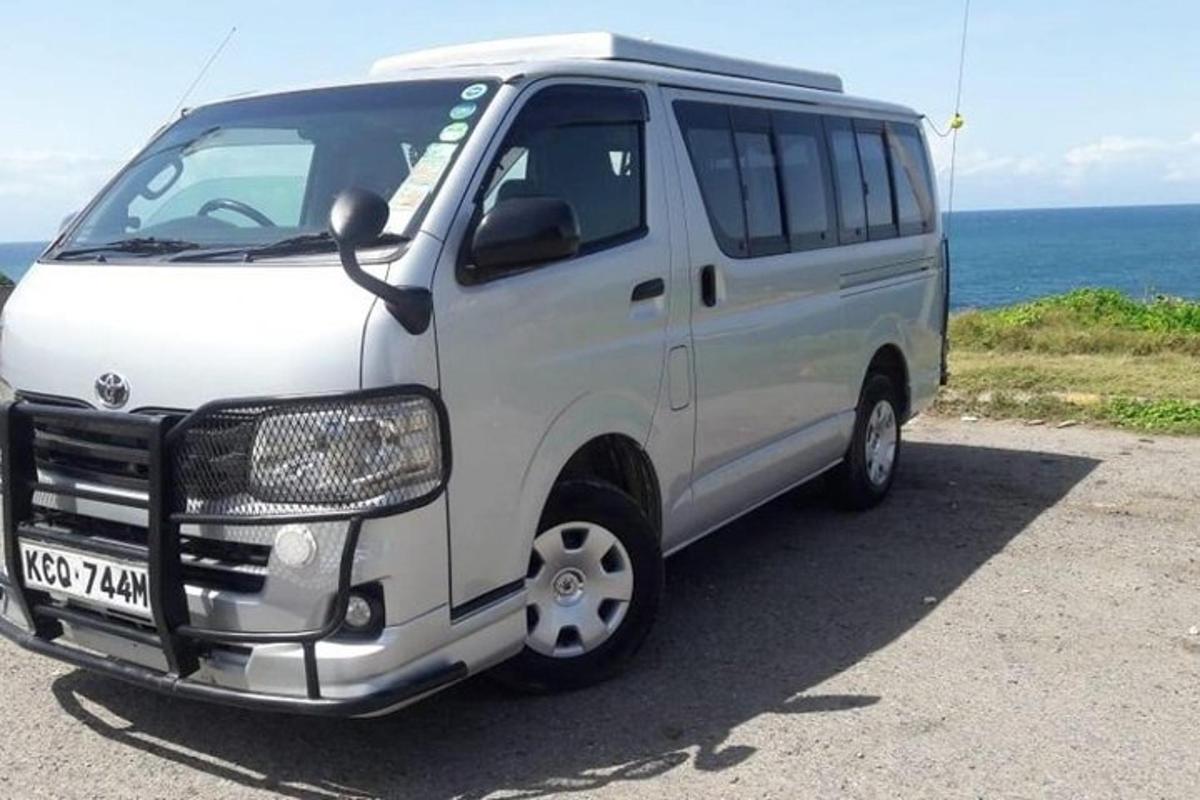 a white van parked next to the ocean