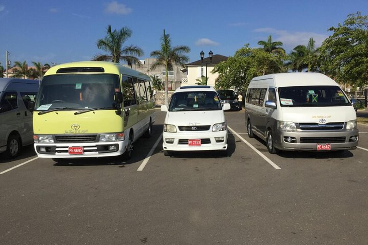 three buses and a van parked in a parking lot