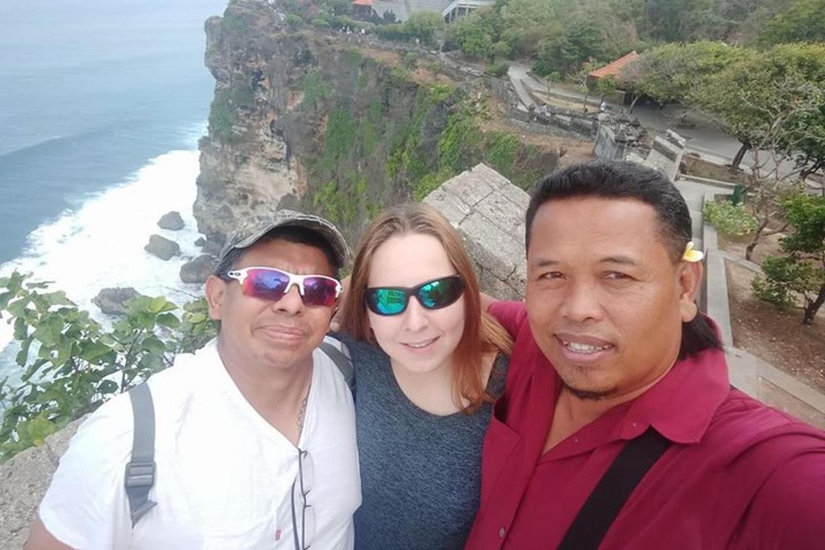 doi bărbați și o femeie care pozează pentru o fotografie la ocean