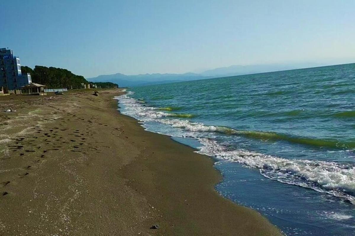plaża ze śladami stóp na piasku i wodzie