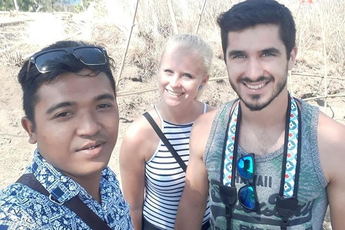 doi bărbați și o femeie care pozează pentru o fotografie
