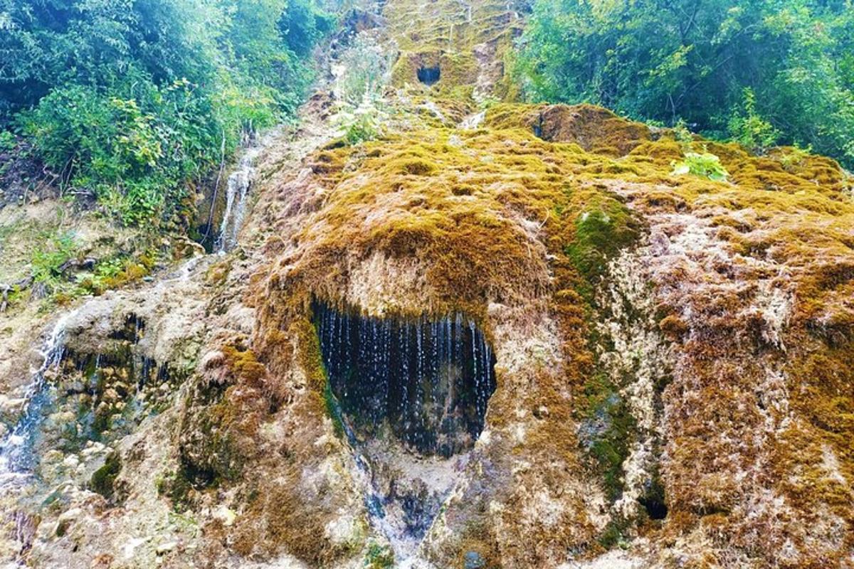 Una vista aérea de una montaña rocosa con una cascada.
