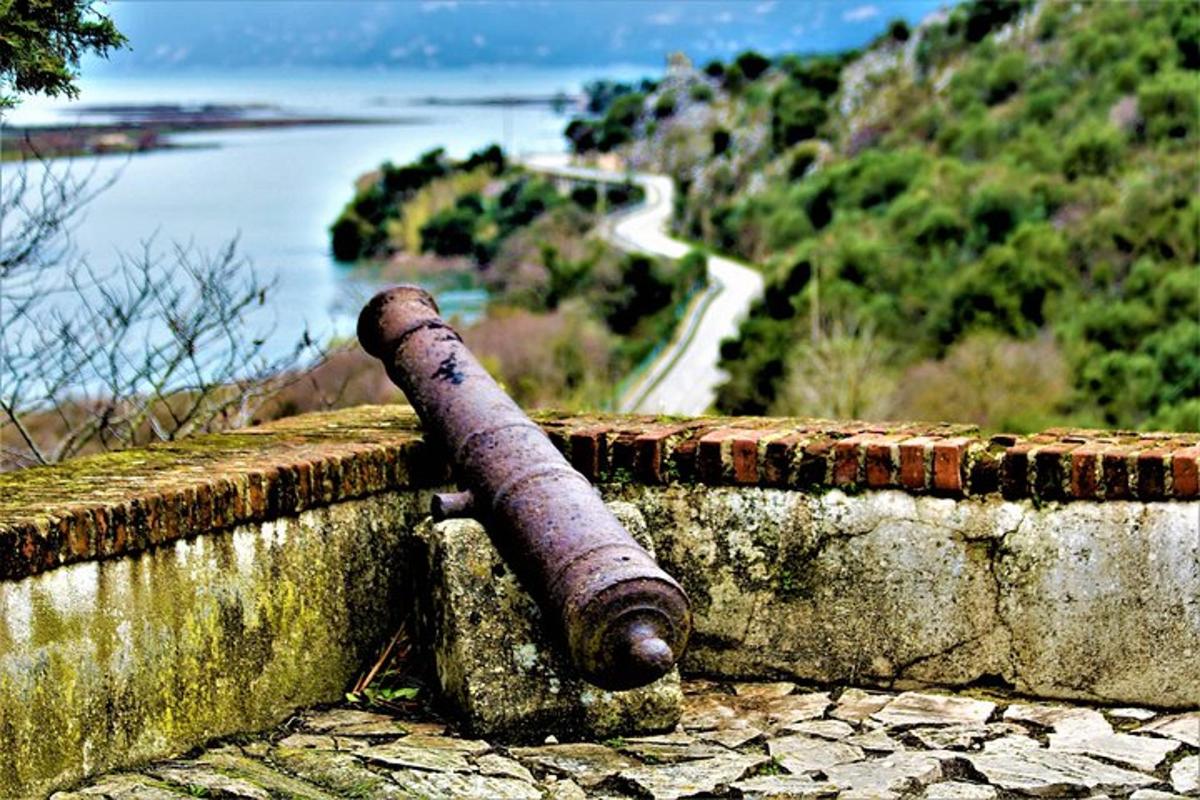 um canhão em um muro de pedra com vista para a água