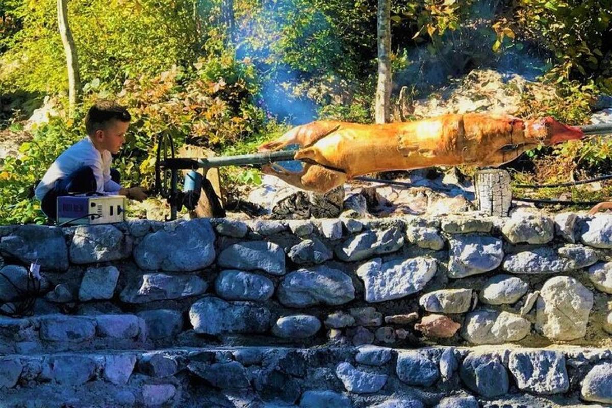 a man holding a gun next to a stone wall
