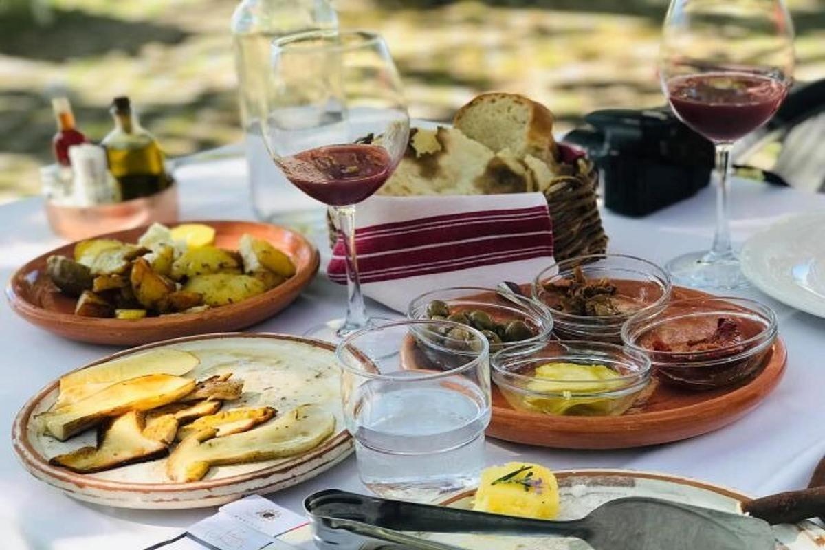 uma mesa coberta com pratos de comida e copos de vinho