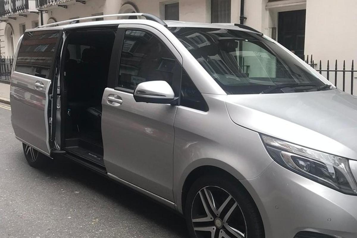 a silver van with its door open on a street
